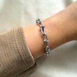 Narukvica - karike II od nehrđajućeg čelika u srebrnoj boji. Čvrsta i moderna lančana narukvica, otporna na vodu i savršena za svaki dan.